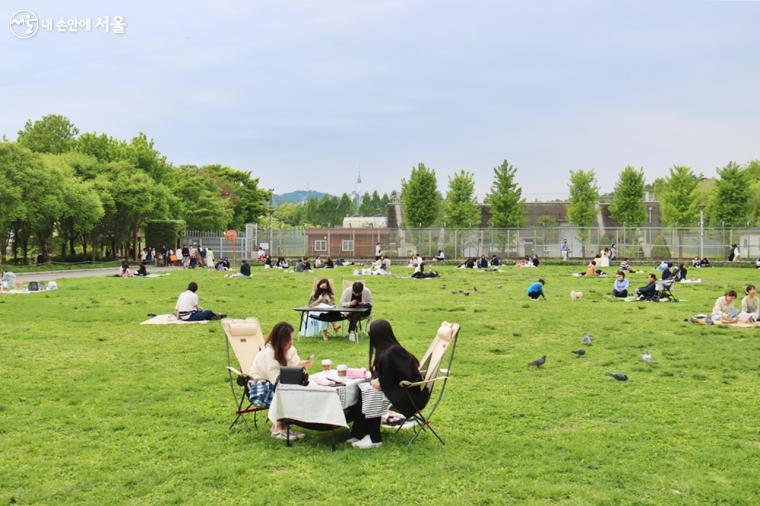 초록 잔디 위에서 시민들이 봄 햇살을 즐기며 여유로운 한때를 보내고 있다. ⓒ정향선 
