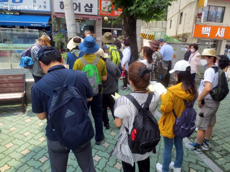  답사 일정과 일부 변경 사항을 알리고 있는 강사 심승구 교수와 참가 시민들