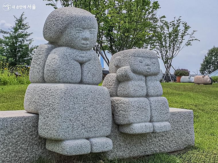 엄마와 아기가 다정하게 앉아서 오손도손 이야기를 나누고 있는 한진섭 작가의 작품 <가득한 사랑>