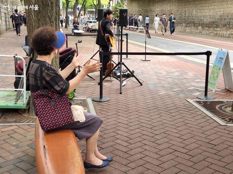 덕수궁 돌담길을 자주 지난다는 행인이 기타로로의 공연을 관람하면서 박수를 치고 있다. ⓒ윤혜숙