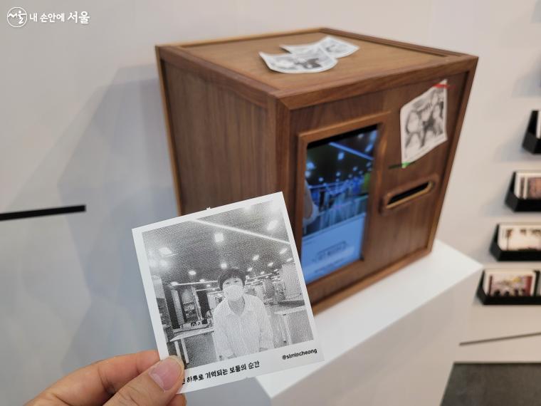 체험존에는 나무 상자 앞면의 카메라를 터치해 사진을 찍으면 인화된 사진이 출력되는 영수증 사진기도 있다. 