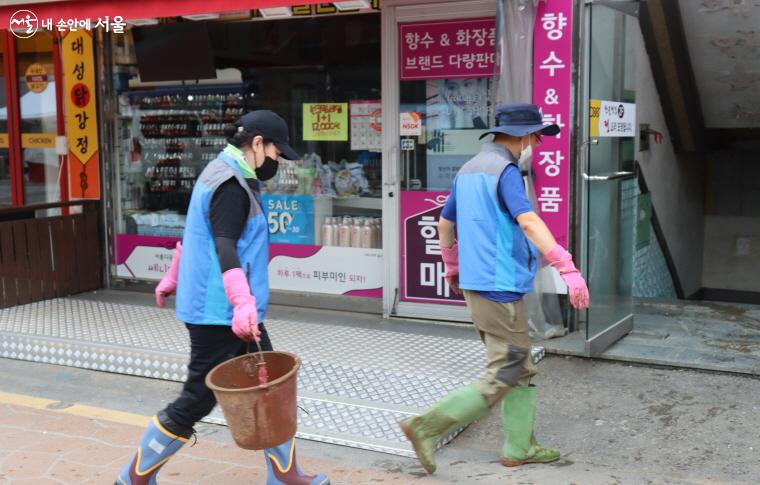 자원봉사자들이 집 안팎을 쉴 새 없이 드나들며 폐기물을 치우고 있다.