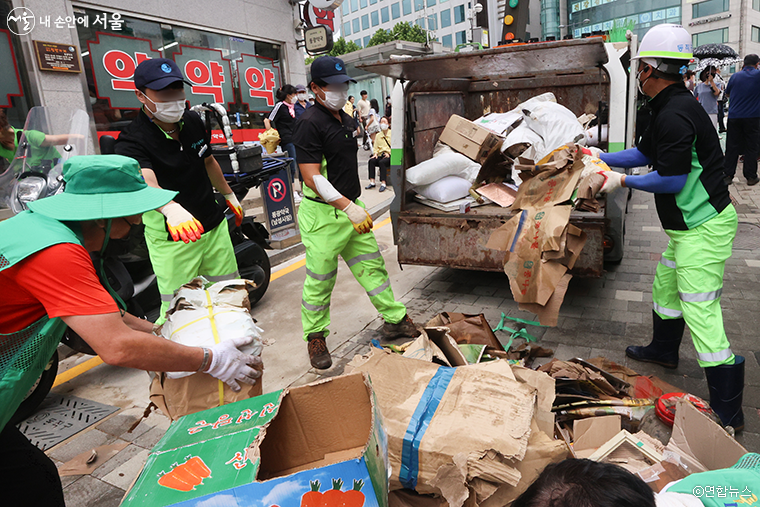 남성사계시장에서 폭우로 발생한 폐기물을 치우는 동작구청 직원들