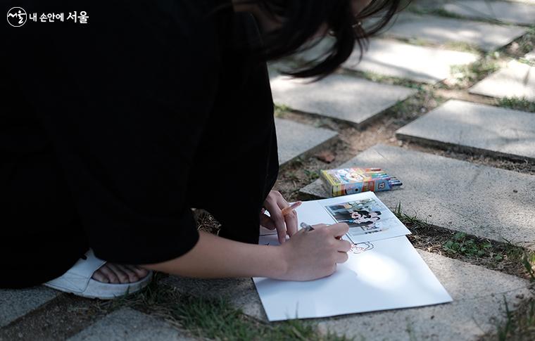 귀여운 반려견과 함께 찍은 사진을 그림으로 표현하는 한 시민 ⓒ김아름