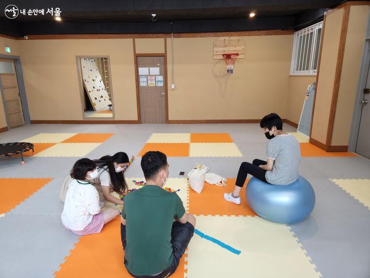 청소년 발달장애인을 위한 체육실에서 여럿이 게임을 즐기고 있다.