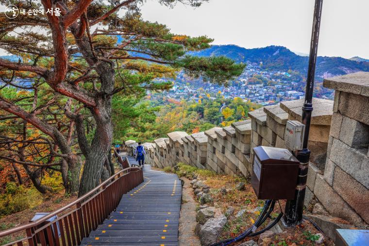 나무 계단으로 이뤄진 등산로를 따라 내려가는 등산객의 모습