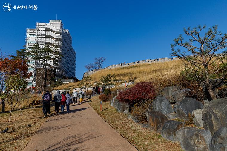 한양도성박물관 옆 낙산성곽길을 걷는 도보해설관광 참가자들과 시민들의 모습 