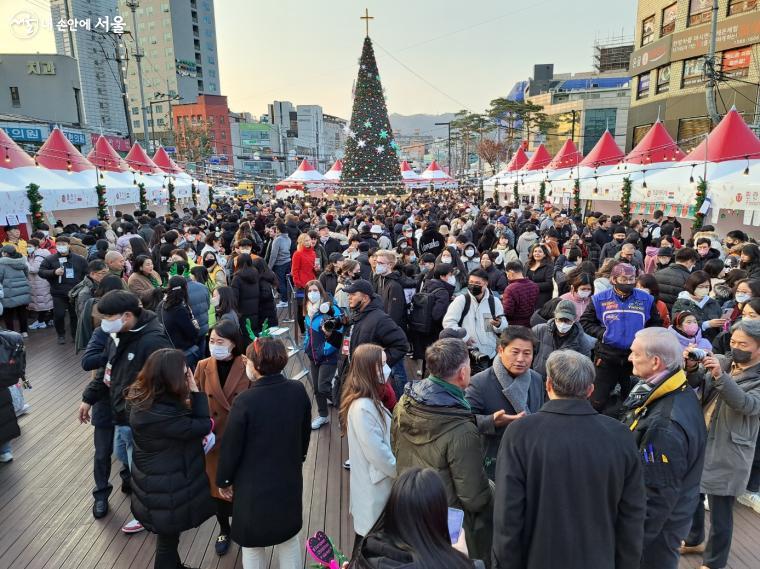 행사장에서 내국인과 외국인이 함께 어울려 행사를 즐기고 대화를 나누고 있다. 