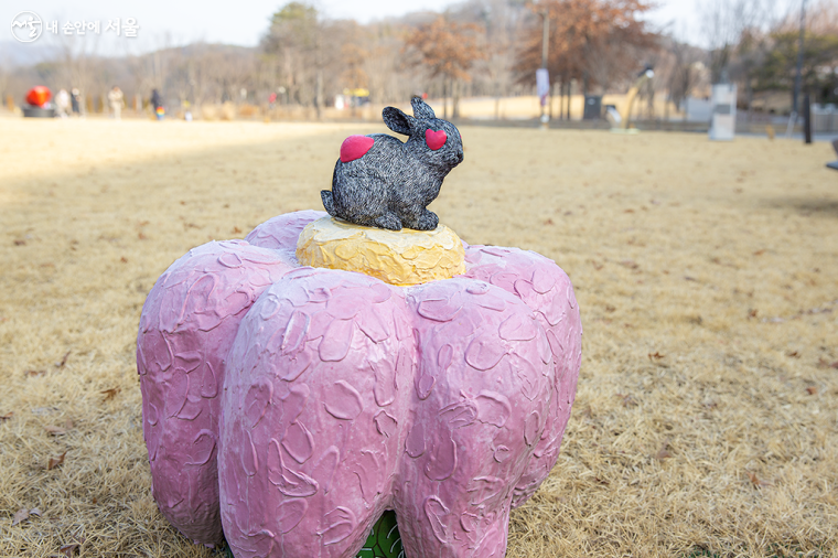 분홍 꽃잎 위에 토끼가 앉아 있는 노승옥 작품 <생각하는 토끼>