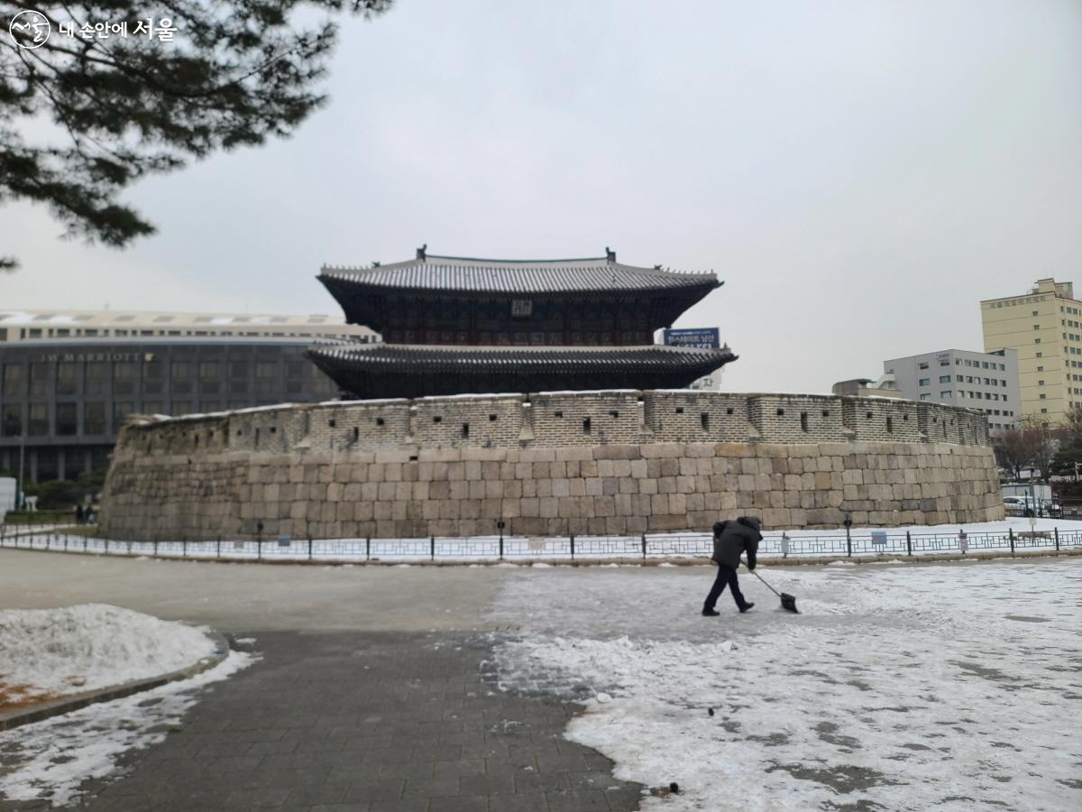 흥인지문 옹성 앞에 쌓인 눈을 넉가래로 쓸어내고 있는 흥인지문 관리직원의 모습 ⓒ이영남