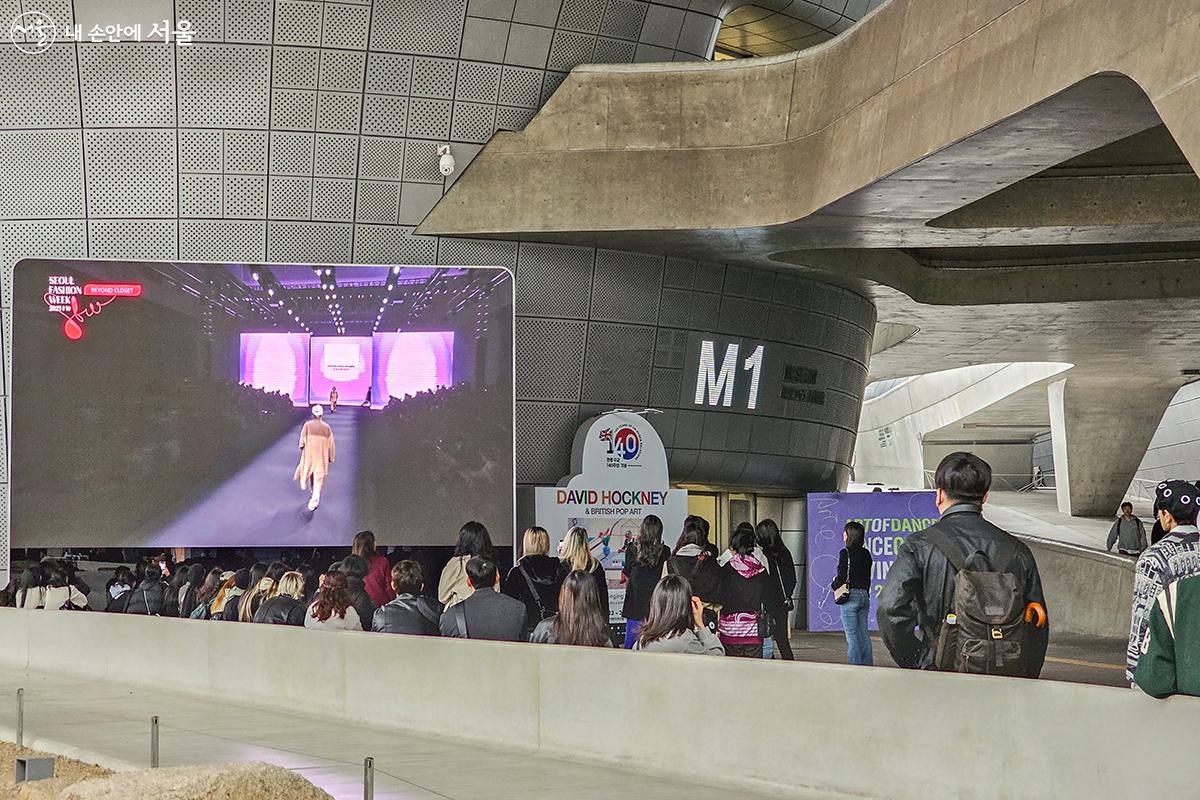 서울패션위크 어울림광장에 설치된 스크린을 통해서도 실내에서 진행 중인 패션쇼를 관람할 수 있었다. ⓒ유서경
