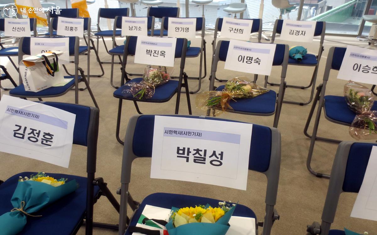 좌석에 참석자들의 이름과 함께 꽃다발이 놓여 있다. Ⓒ박칠성