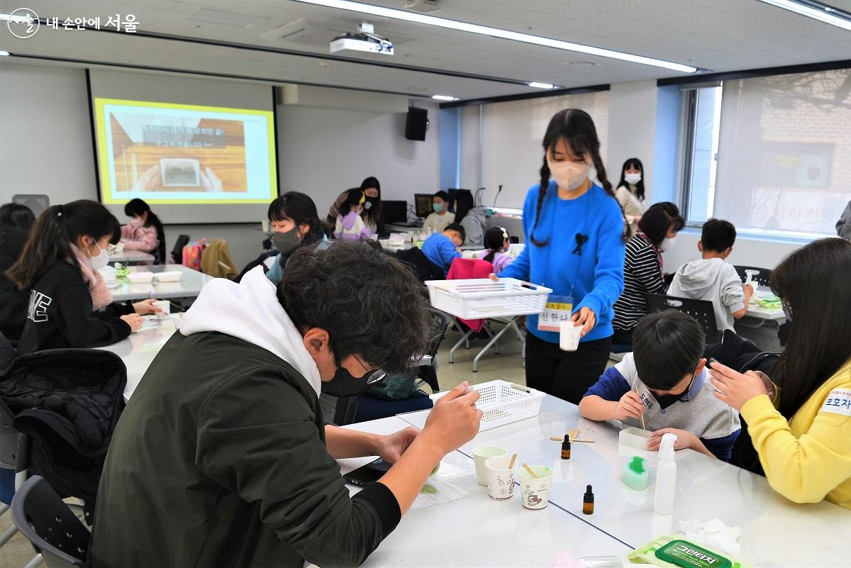 수업 도우미들이 각각의 과정마다 필요한 재료를 나누어 주며 원활한 진행을 돕고 있다. ©이봉덕