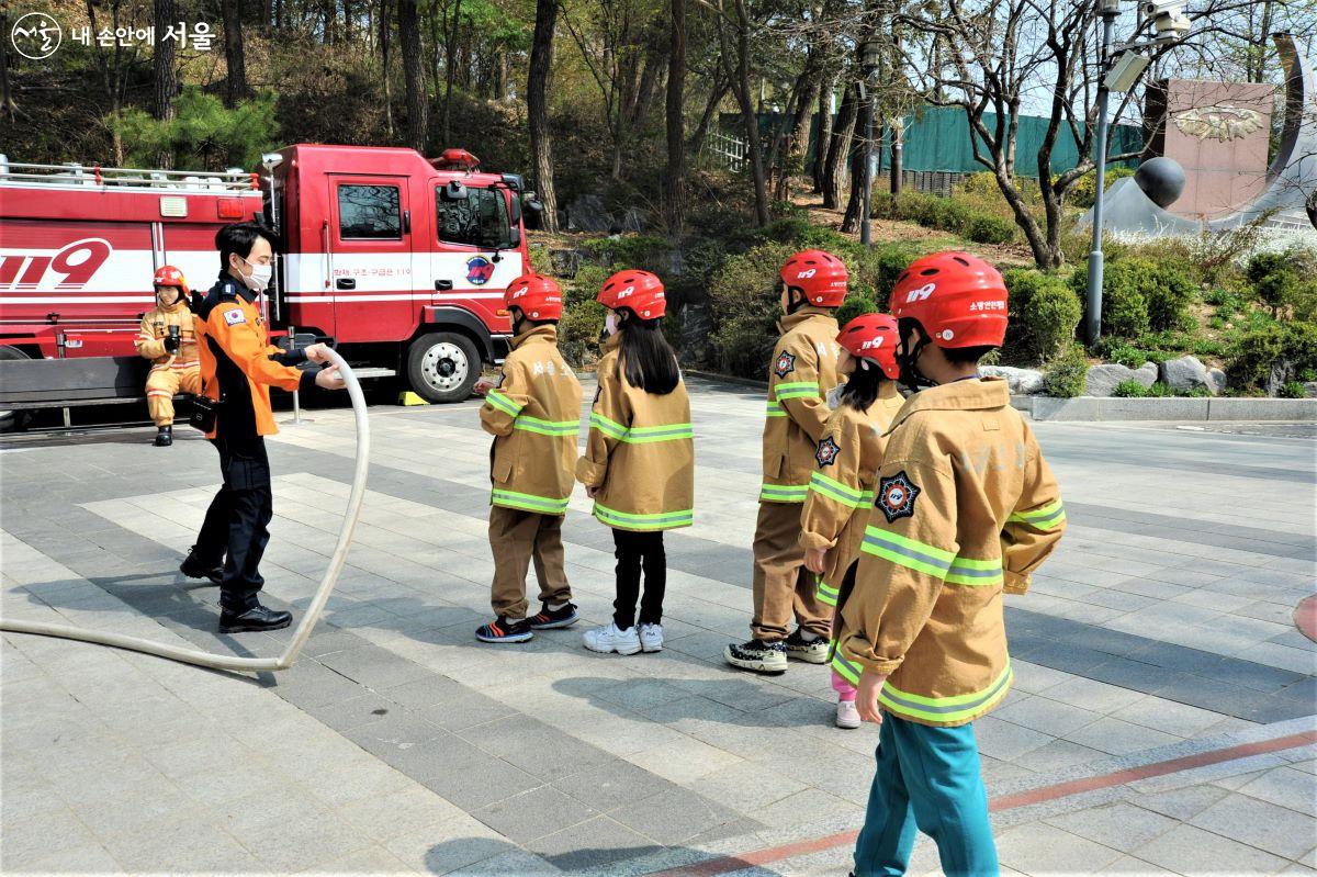 옥외에서 실제 소방호스 작동 체험을 준비 중인 어린이 참여자들 ⓒ조수봉