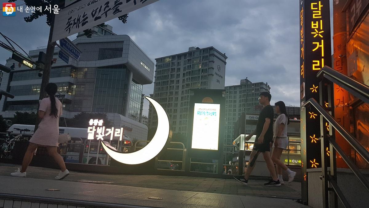 9호선 염창역 4번 출구 앞, ‘용왕산 달빛거리’ 포토존 앞을 시민들이 지나가고 있다. ©박분