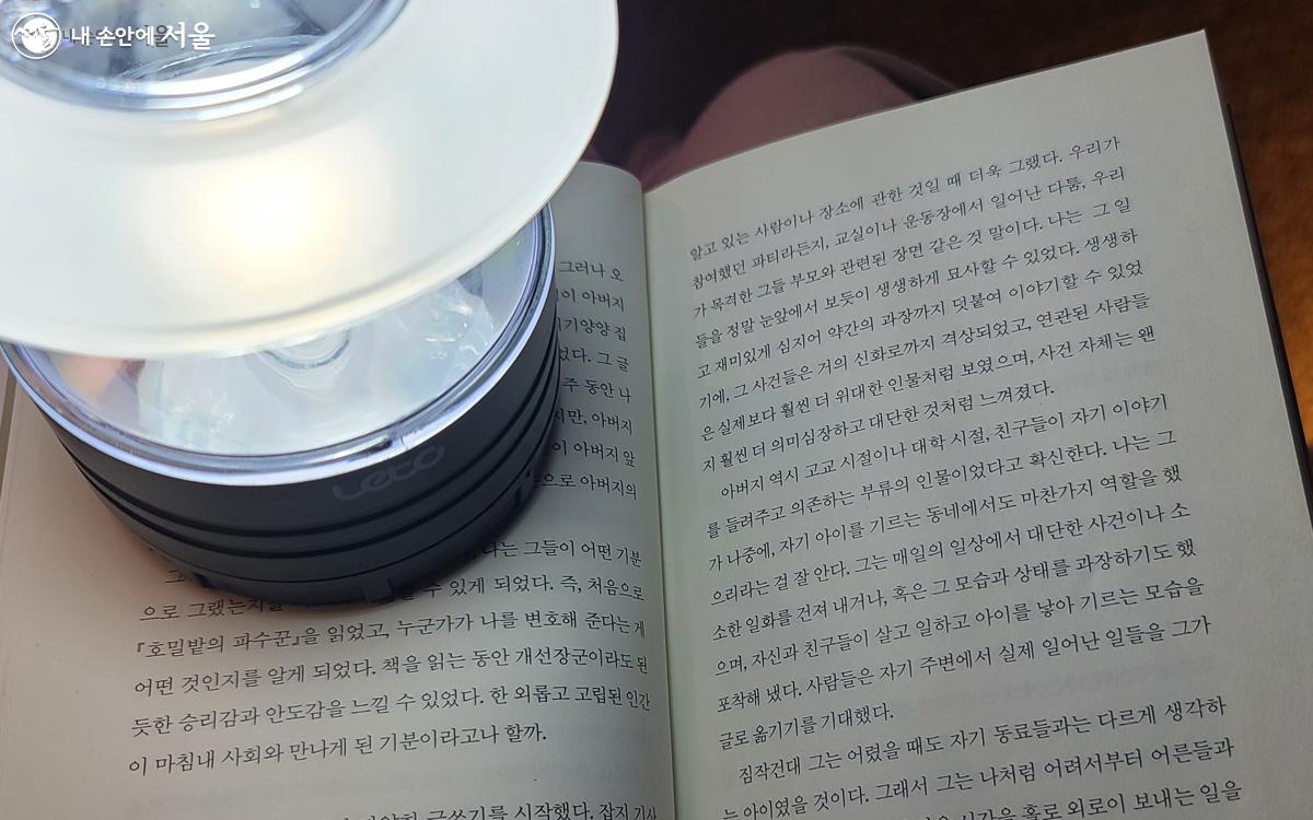 반딧불과 눈빛보다 100배는 더 밝은 듯한 ‘독서등’을 대여해 광화문 광장에서 야간 독서를 하는 기쁨을 경험할 수 있다. ⓒ김경희