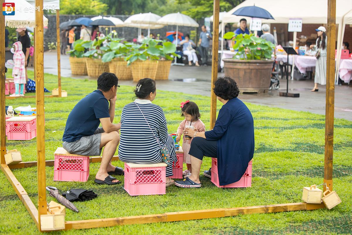 잔디마당에 설치된 파고라 안에서 가족들이 푸른수목원의 주말 축제를 즐기고 있다. ⓒ임중빈