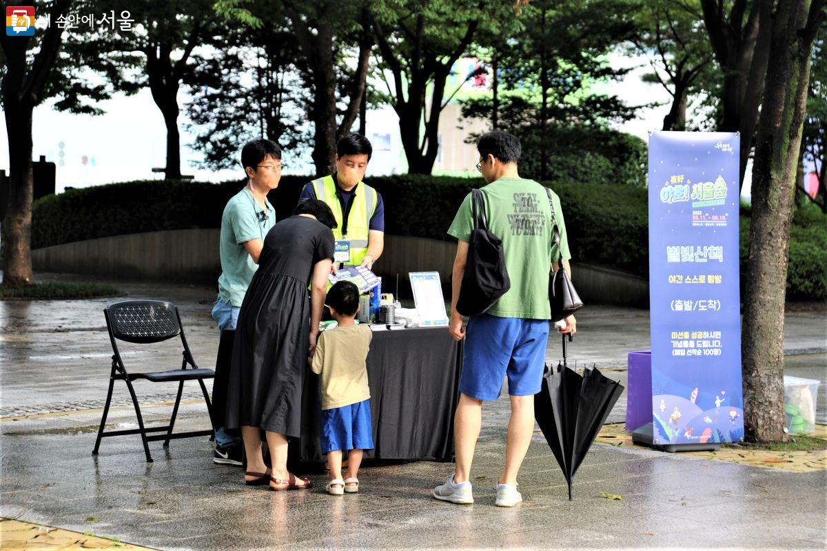 미션지를 받고 서울숲 곳곳을 돌며 미션을 완성하는 ‘야간 스스로 탐방’ 프로그램을 신청하는 가족 ⓒ조수봉