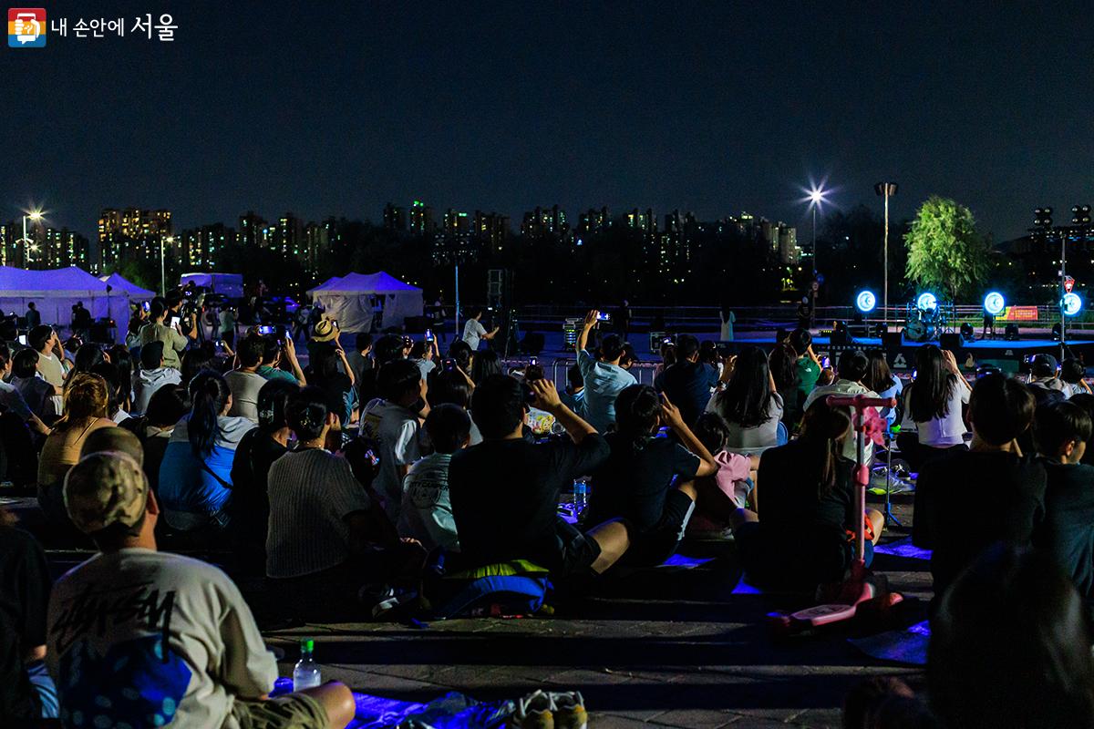 뚝섬한강공원 드론라이트쇼가 펼쳐지고 있는 수변무대를 찾은 시민들이 아름다운 장면을 각자의 휴대폰에 담고 있다. ©유서경