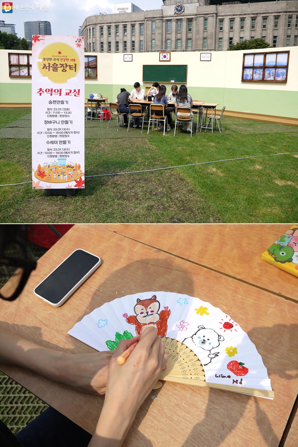 서울광장 중앙에 마련된 추억의 교실에서 시민들이 부채에 그림을 그리고 있다. ©최윤영