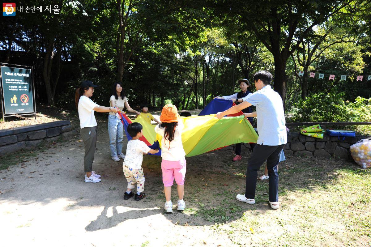 엄마, 아빠와 함께 파라슈트 놀이를 하고 있는 어린이들 ⓒ조수봉