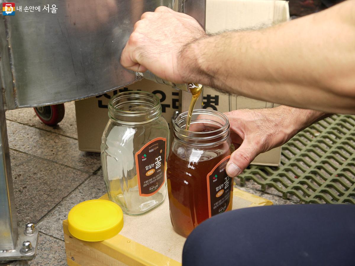 전북 임실군 부스에서 꿀을 병에 담는 모습을 볼 수 있었다. ©최윤영