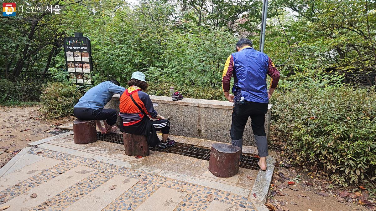 황톳길 이용자가 발을 씻고 있다. Ⓒ이성식