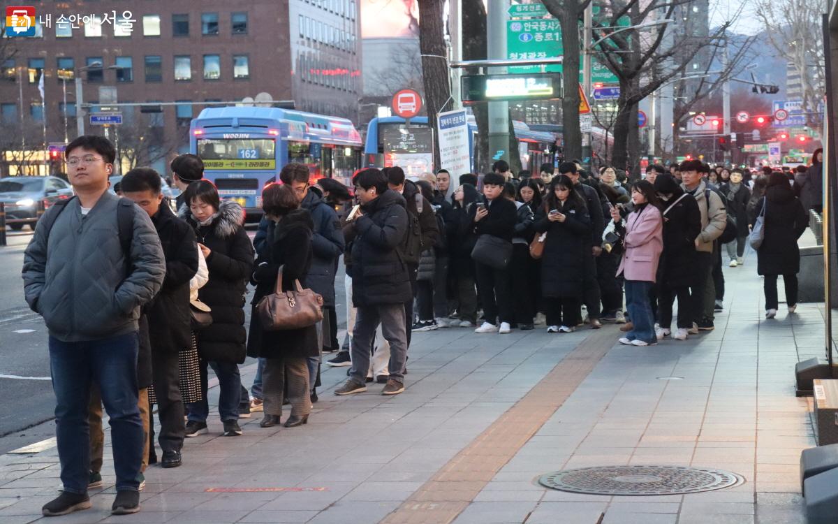 명동입구 정류소에 퇴근길 버스를 기다리는 시민들이 줄지어 있다. ©조수연