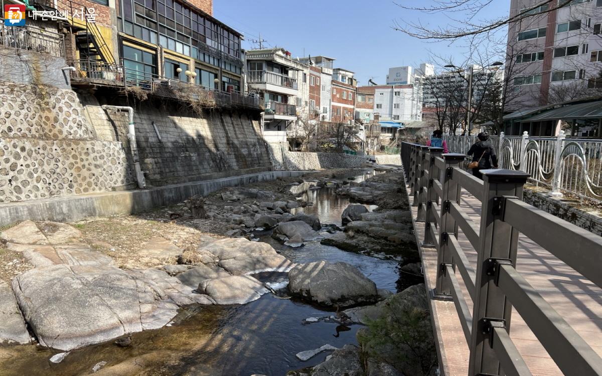 개천가에 설치된 나무 데크를 따라 시민들이 가벼운 걷기 운동을 하고 있다. ©박지영 