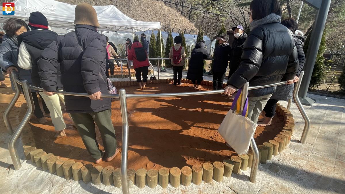 야외 황토족탕에서 발마사지 중인 시민들