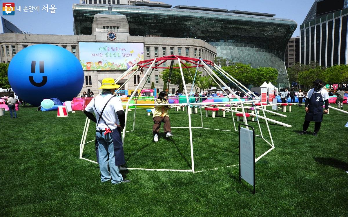 엄마·아빠·아이를 위한 ‘창의 놀이터’가 광장 중앙에 조성됐다. 사진은 구조물 안에서 그네를 탈 수 있는 ‘테라리움’ ©조수봉