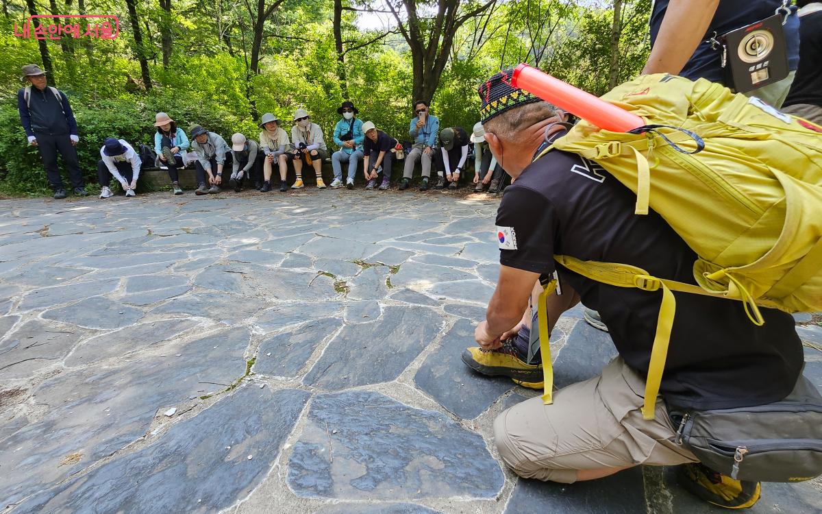 등산 지도사가 참가자들에게 올바른 등산화 끈 묶는 방법을 교육하고 있다. ©김준범