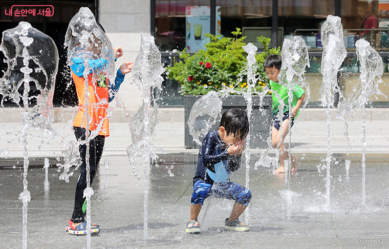 광화문광장 분수대에서 어린이들이 물놀이를 하며 즐거운 시간을 보내고 있다.