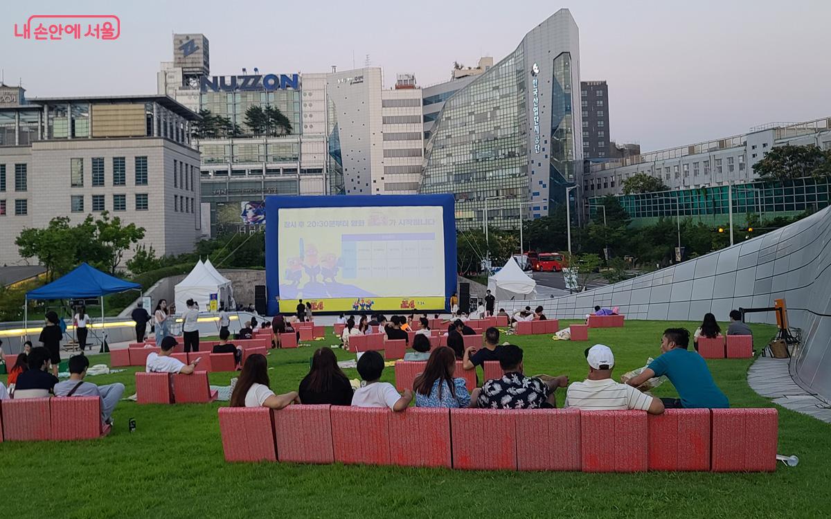 저물녘 잔디언덕에서 피크닉을 즐기고 영화를 감상하기 위해 삼삼오오 모였다. ©김경희