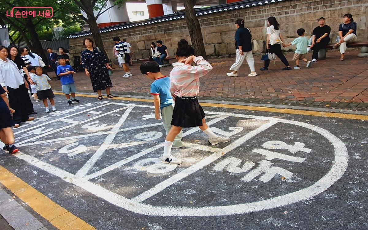 사방치기, 제기차지, 딱지치기 등이 진행되며 아이들의 놀이터로 변신한 차 없는 거리 ©엄윤주 