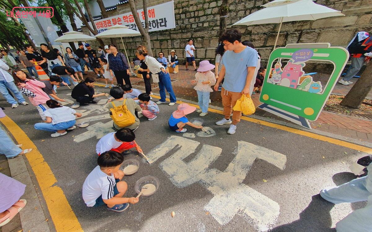 황토와 EM효소 등을 활용해 만든 물감으로  거리에 시민들이 그린 꽃길 드로잉 퍼포먼스 ©엄윤주 