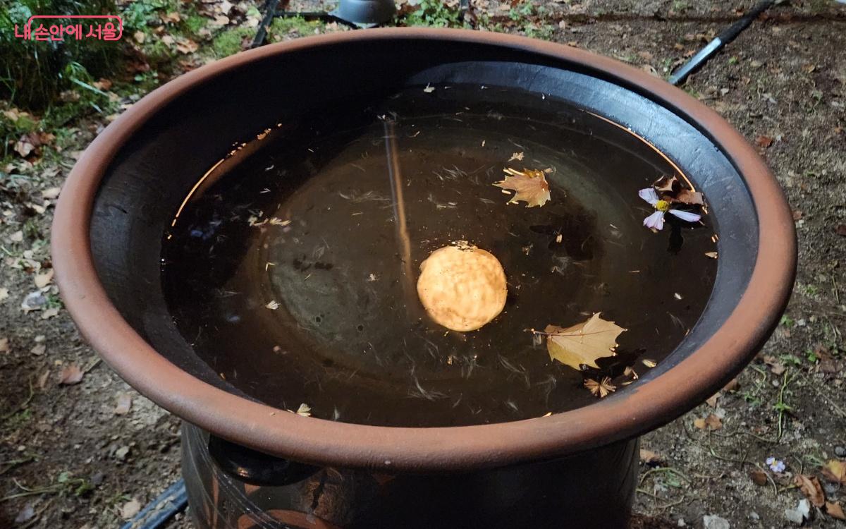 항아리 위 뚜겅의 물에 비치는 작품 '불을 밝힌 달' ©김미선