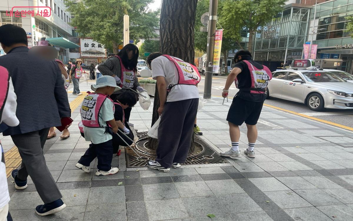 가로수 철제 보호대 틈 사이에 낀 꽁초와 쓰레기를 줍는 모습 ⓒ이정민 