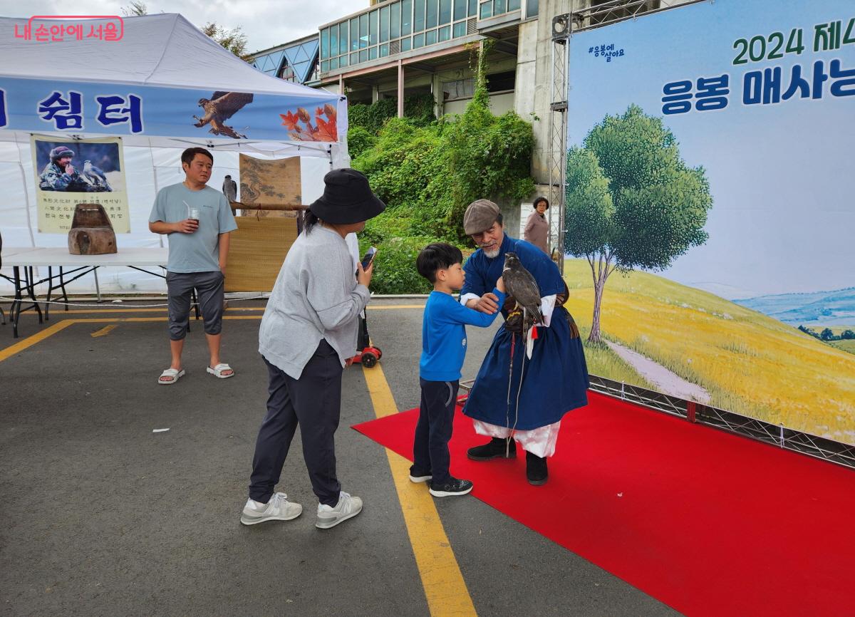 아이가 신기한 듯 바라보자 매사냥꾼이 매를 만져 볼 수 있게 지도했다. ⓒ조시승