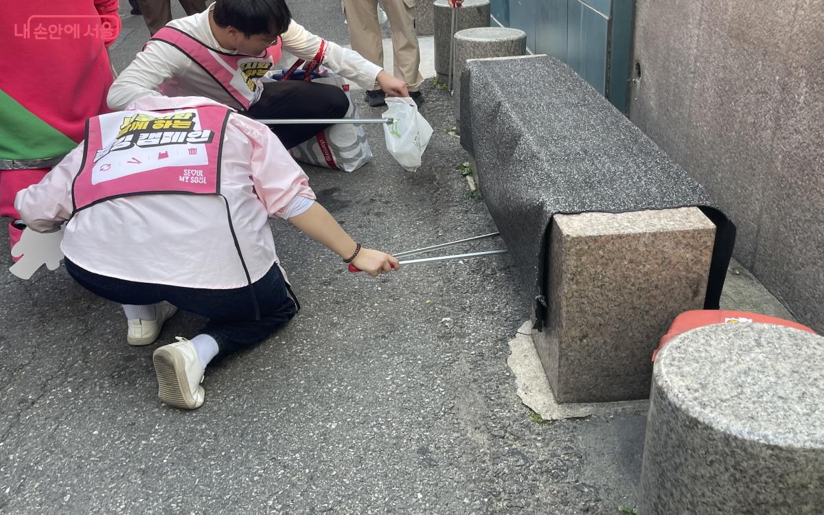 벤치 아래에 숨은 쓰레기 하나까지 열심히 줍고 있다. ⓒ이정민 