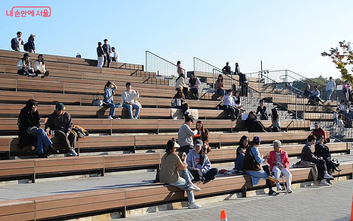 잔디마당 나무 스탠드에서 음식을 먹으며 즐거운 시간을 보내는 시민들 ©오도연 