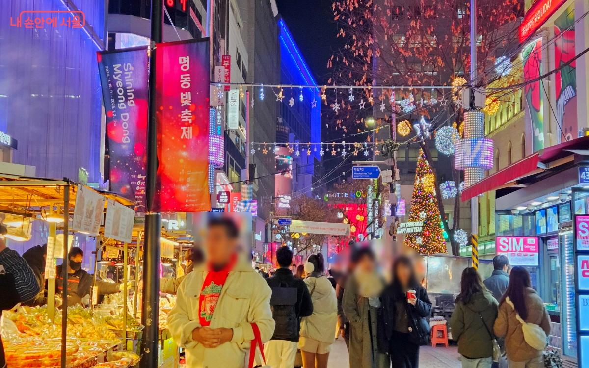 ‘명동 빛축제’ 깃발이 나부끼는 거리에 인파가 가득했다. ⓒ이선미 