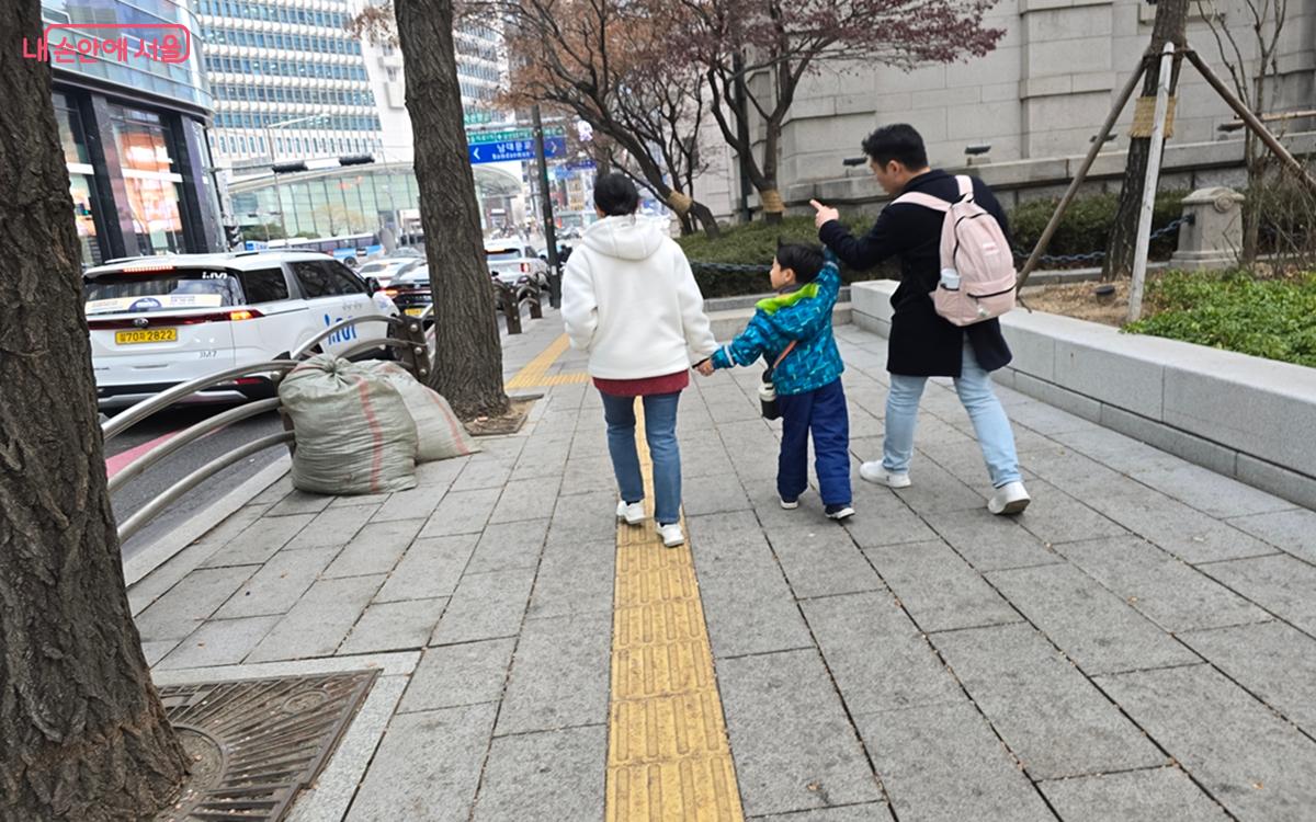 넓은 도로에서 엄마, 아빠 손을 잡고 신나 하는 아이의 모습 ©김윤경