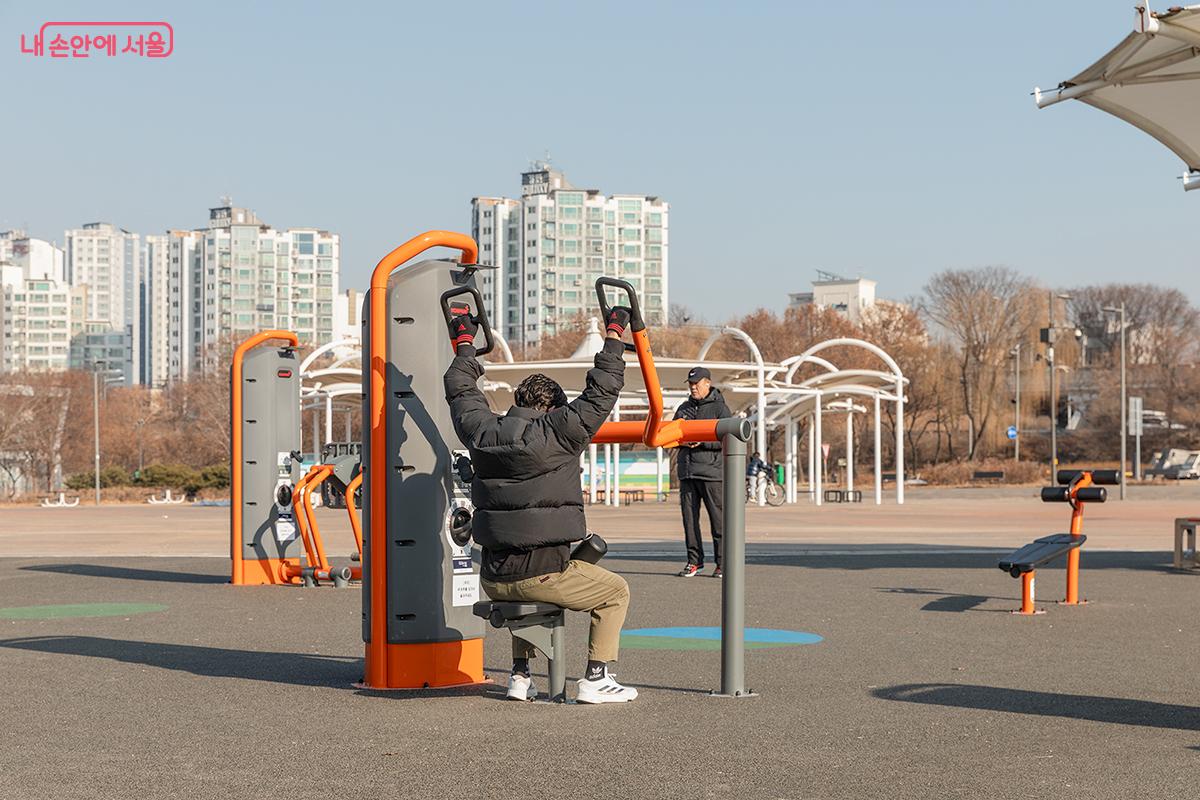 광나루한강공원 한강 헬스장을 찾은 한 시민이 숄더프레스 동작을 취하고 있다. ©문청야