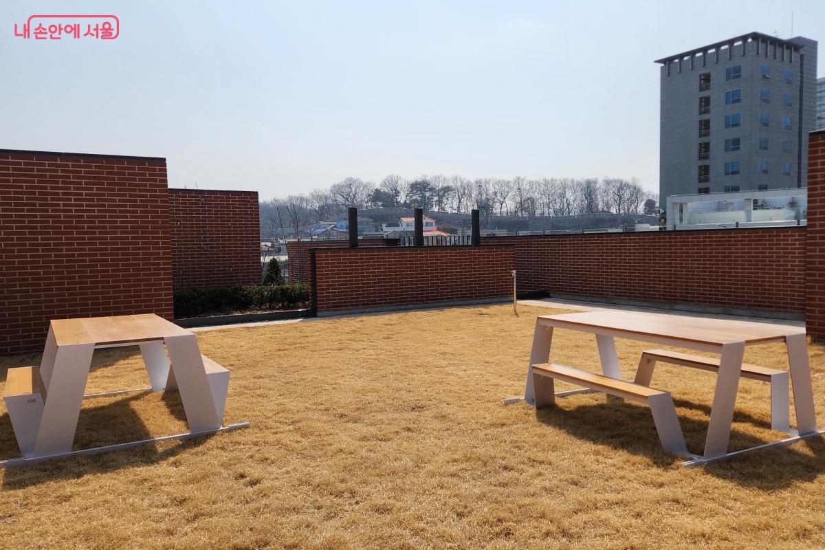 잔디 위에 설치된 의자에 앉아 한양도성 풍경을 마주한다. ©김미선