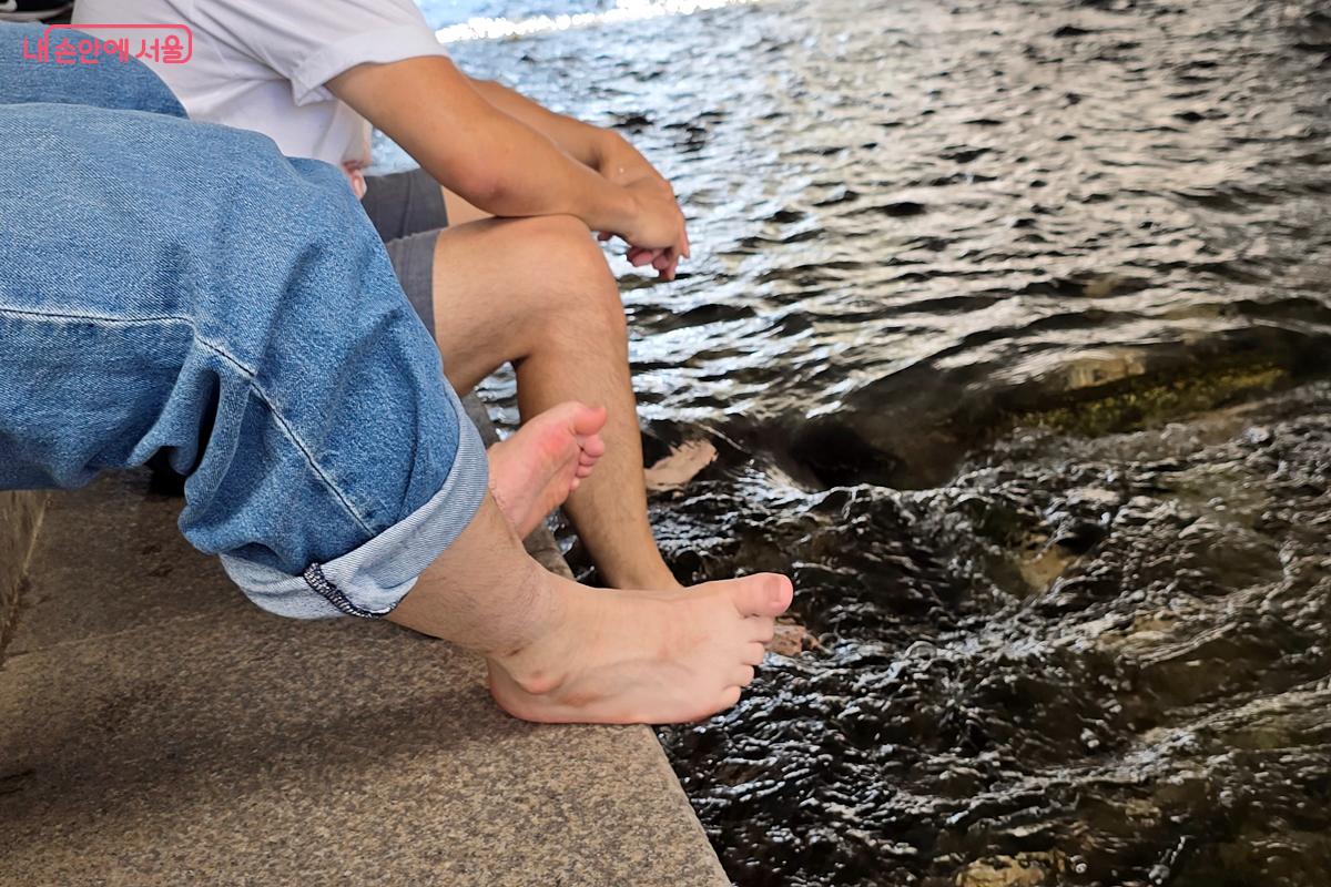 길 가다가 합류한 두 사람이 청계천에 발을 담그고 있다. ©김윤경
