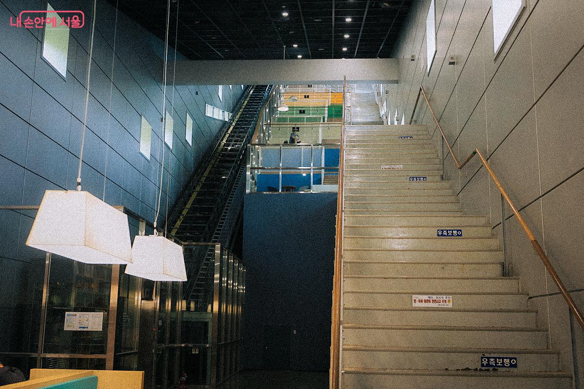 옥내에도 경사형 엘리베이터가 있으며, 오른쪽 계단을 걸어 올라가도 좋다. 중간쯤에 도서관에서 책을 가져와 독서를 즐길 수 있는 공간이 조성돼 있다. ©김아름