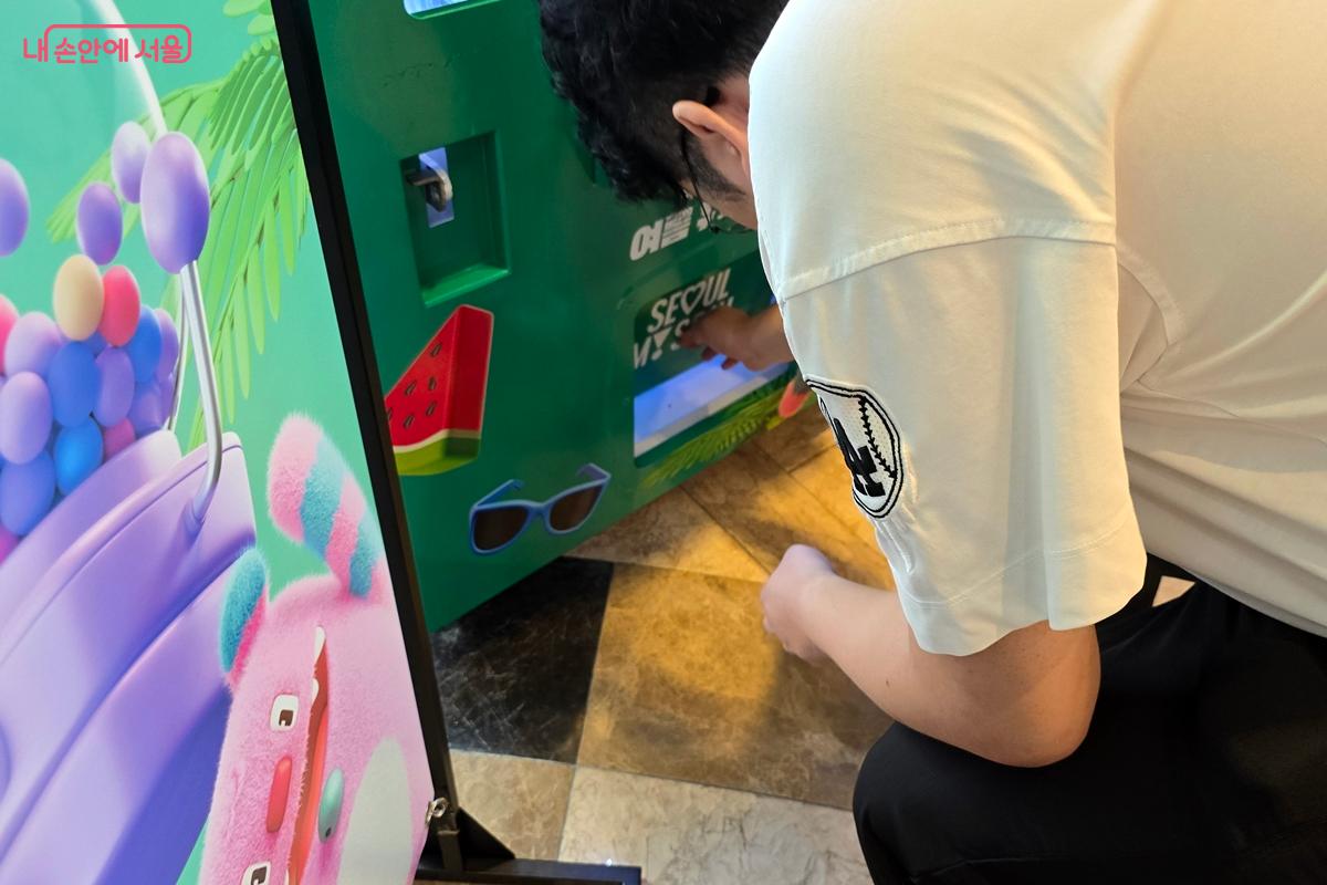 캡슐을 꺼내보는 시민 ©김윤경