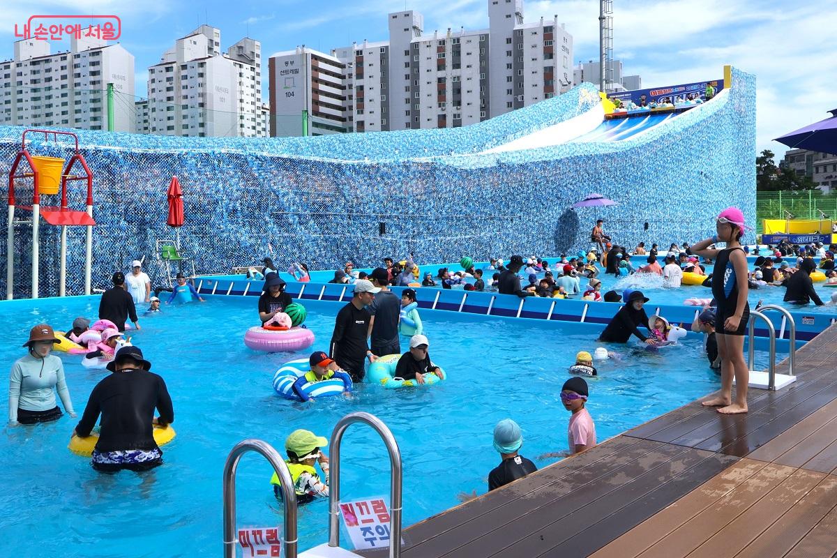 시원한 풀장에서 온 가족이 함께 즐겁게 놀고 있다.