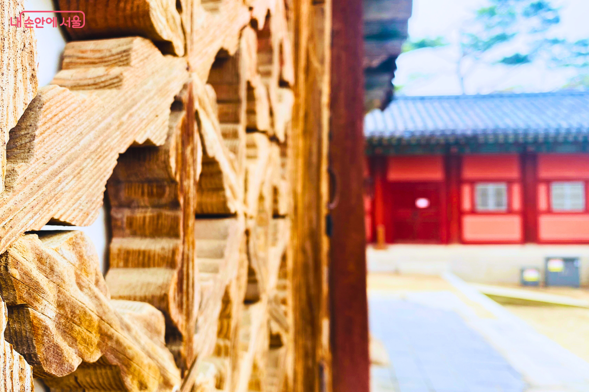 명정전 꽃살무늬 창 뒤로 아스라이 행각이 보인다. ©양정화